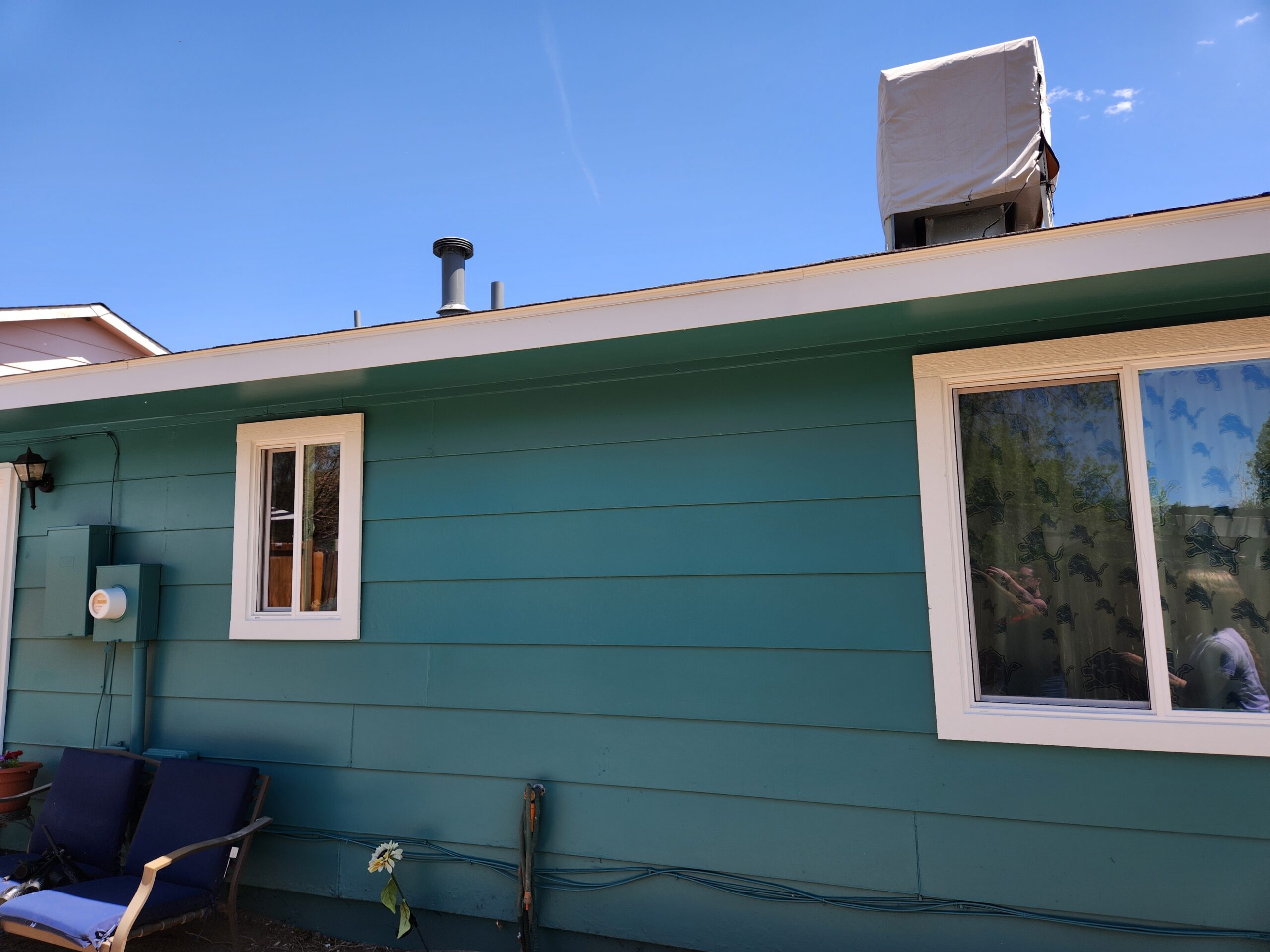 A photo of the brown home with new windows and gutters